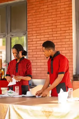 two people standing in a kitchen preparing food at Kilimont Hotel