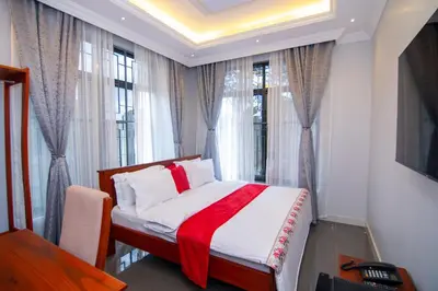 a bedroom with a bed with a red blanket at Kilimont Hotel