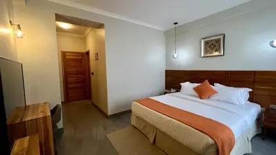 a bedroom with a large bed and a wooden headboard at Iwandaa Lodge in Nkoanrua