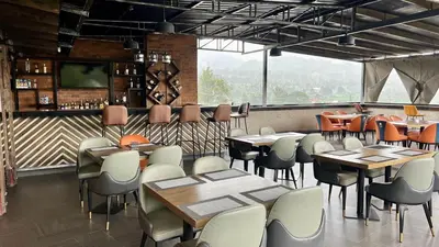 a restaurant with tables and chairs and a bar at Iwandaa Lodge in Nkoanrua