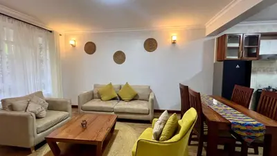 a living room with a couch and a table and chairs at Iwandaa Lodge in Nkoanrua