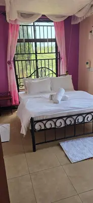 a bed in a room with a large window at Greenhome apartment in Poli