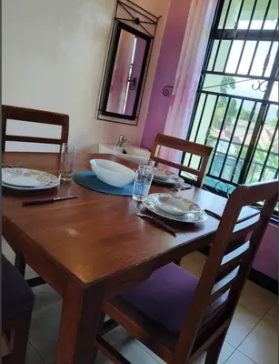 a wooden table with two chairs and a sink at Greenhome apartment in Poli