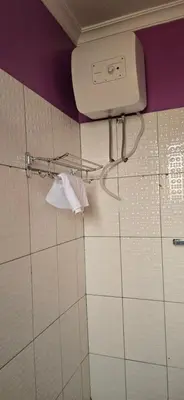 a bathroom with a toilet paper dispenser on the wall at Greenhome apartment in Poli