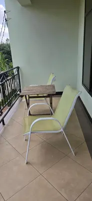 a table and a chair sitting on a balcony at Greenhome apartment in Poli