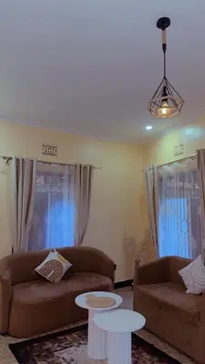 a living room with two couches and two tables at Cozy 1Bedroom Stand Alone -Near Clock Tower Arusha in Arusha