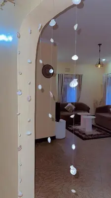 a room with a mirror with lights hanging from it at Cozy 1Bedroom Stand Alone -Near Clock Tower Arusha in Arusha