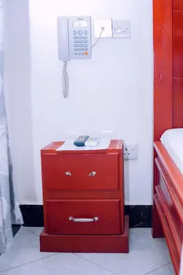 a red dresser with a phone on a wall at Panamera Safari Lodge in Boma la Ngombe