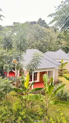 a red house in the middle of a forest at Two rivers lodge in Arusha
