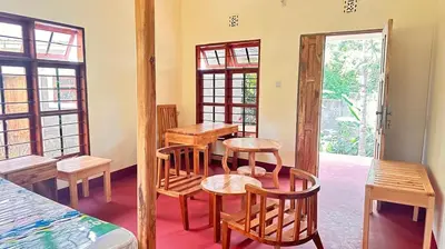 a room with wooden chairs and tables and a room with windows at Two rivers lodge in Arusha