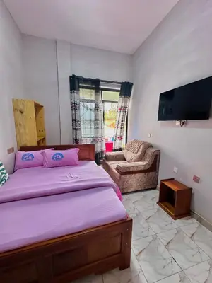 a bedroom with a bed and a flat screen tv at Mbogo Safari Hotel in Karatu