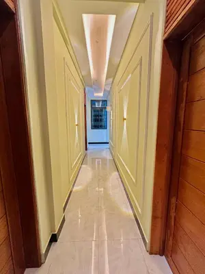 a hallway with yellow walls and a tile floor at Mbogo Safari Hotel in Karatu