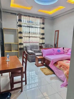 a living room with a bed and a table at Mbogo Safari Hotel in Karatu