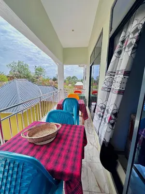 a balcony with a table and chairs on a balcony at Mbogo Safari Hotel in Karatu