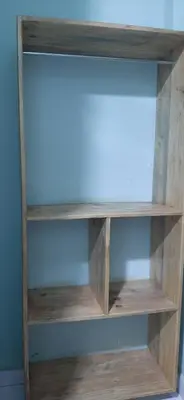 a book shelf with wooden shelves in a room at Mbogo Safari Hotel in Karatu