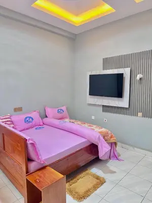 a bedroom with a bed and a flat screen tv at Mbogo Safari Hotel in Karatu