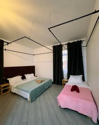 a bedroom with two beds and a large window at Araess Homestay Karatu in Karatu