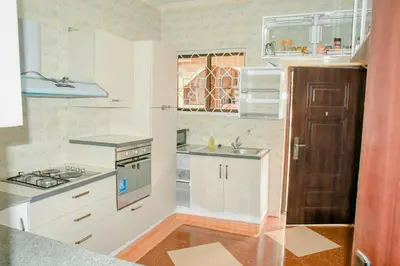 a small kitchen with white cabinets and a sink at Kilimanjaro Serenity Lodge & Camp