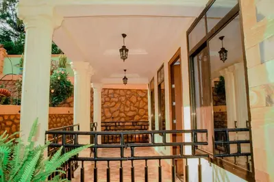a balcony of a home with a stone wall at Kilimanjaro Serenity Lodge & Camp