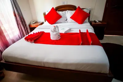 a bed with red pillows and a red blanket at Explora Lodge in Arusha