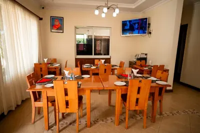 a dining room with a wooden table and chairs at Explora Lodge in Arusha