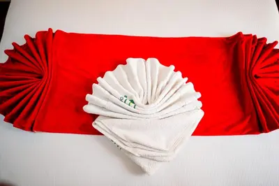 a red pillow with a white towel on it at Explora Lodge in Arusha