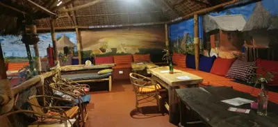 a room with tables and chairs and a painting on the wall at Camp Kimanganu Safari Lodge in Msaranga