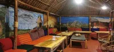 a room with tables and chairs and a mural at Camp Kimanganu Safari Lodge in Msaranga