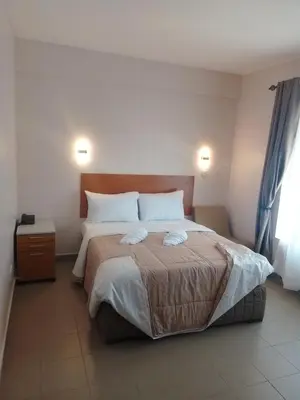 a bedroom with a large bed with two pillows at Atlas Hotel in Arusha