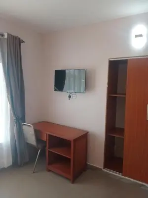 a room with a desk and a tv on a wall at Atlas Hotel in Arusha