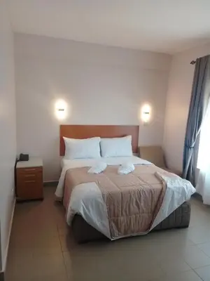 a bedroom with a bed with two towels on it at Atlas Hotel in Arusha