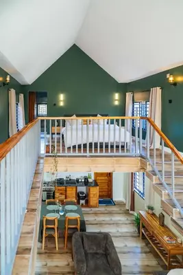 a living room with a staircase and a table and chairs at Starico Residence in Nkoanrua