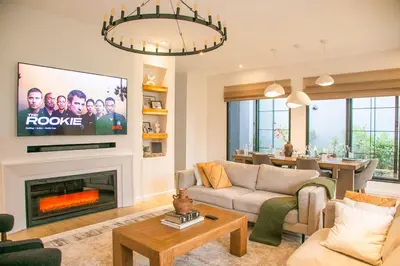 a living room with a fireplace and a tv at Modern Farmhouse & French Elegance Stay for 6 in Arusha