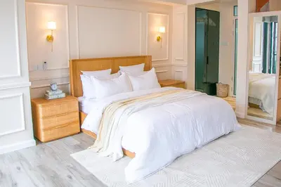 a white bedroom with a large bed with white sheets at Modern Farmhouse & French Elegance Stay for 6 in Arusha