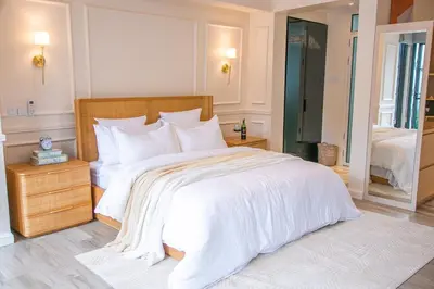 a white bedroom with a large bed with white sheets at Modern Farmhouse & French Elegance Stay for 6 in Arusha