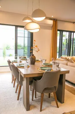 a dining room with a large wooden table and chairs at Modern Farmhouse & French Elegance Stay for 6 in Arusha