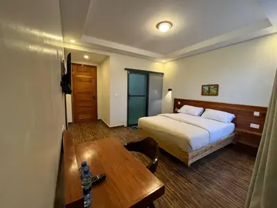 a hotel room with a bed and a table at Boma masai Garden in Boma la Ngombe