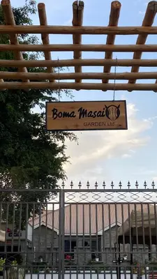 a sign hanging from a fence in front of a building at Boma masai Garden in Boma la Ngombe