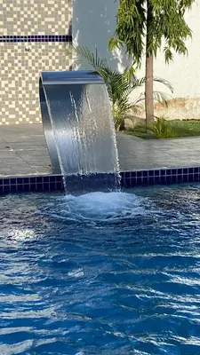 a fountain in the middle of a pool of water at Boma masai Garden in Boma la Ngombe