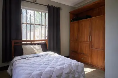 a bedroom with a bed and a large window at Kobe House in Olturoto