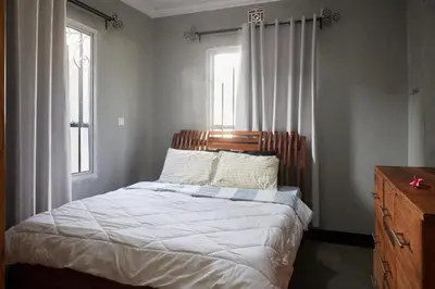 a bedroom with a bed with a wooden headboard and a window at Kobe House in Olturoto