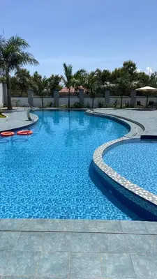 a large blue swimming pool with two red frisbees in it at Boma masai garden in Boma la Ngombe