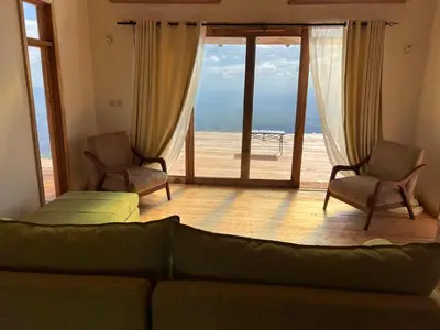 a living room with a couch and a view of the ocean at Shume cliffs in Manga