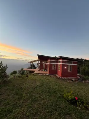 a house on a hill with the sunset in the background at Shume cliffs in Manga