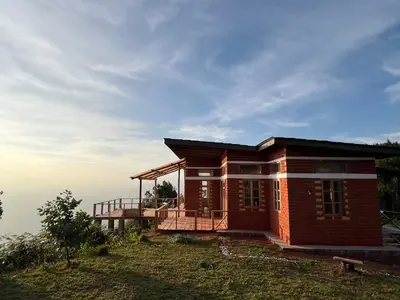 a house on top of a hill with the sky at Shume cliffs in Manga