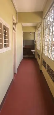 a hallway with a red floor and glass windows at Uhuru Peak Hostel in Moshi