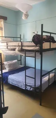 a room with three bunk beds in a room at Uhuru Peak Hostel in Moshi