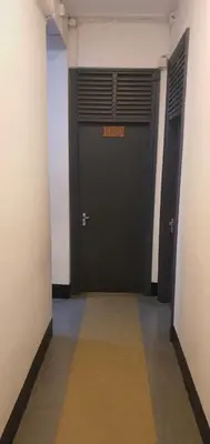 a hallway with two black doors in a building at Uhuru Peak Hostel in Moshi