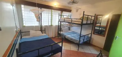 a room with two bunk beds and a mirror at Uhuru Peak Hostel in Moshi
