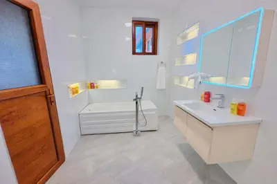 a white bathroom with a tub and a sink at Peak Hotel & Safaris in Karatu